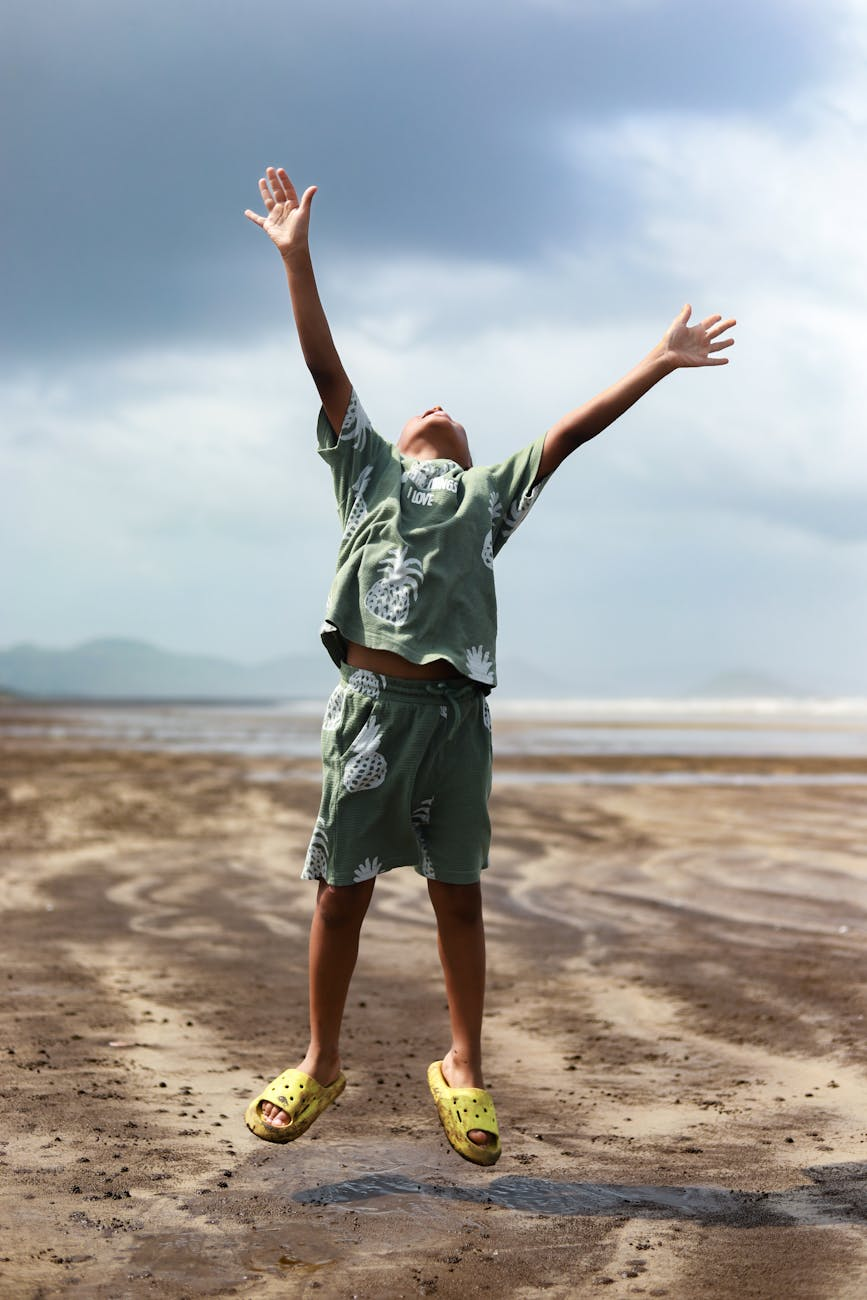 joyful child jumping on a sandy beach